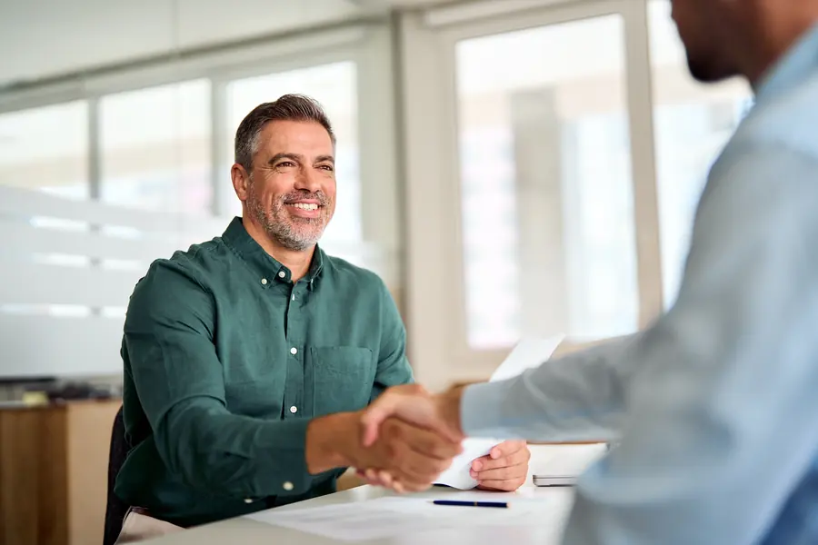 Cliente estrechando la mano tras revisar una factura de taller